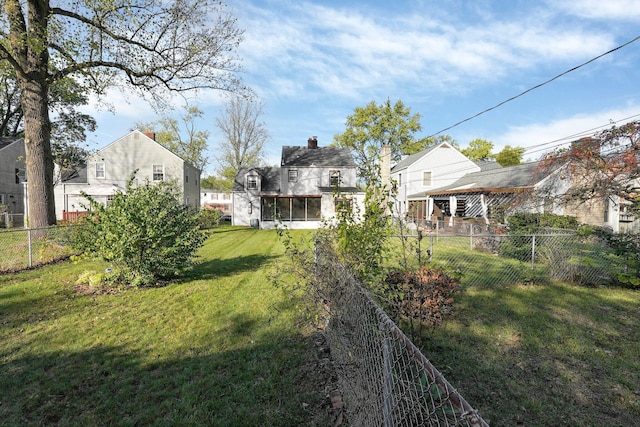 view of yard featuring a fenced backyard and a sunroom