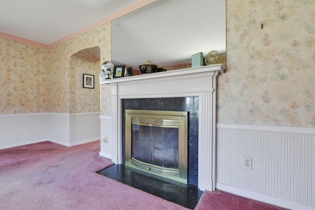 room details featuring a high end fireplace, carpet floors, wainscoting, and wallpapered walls