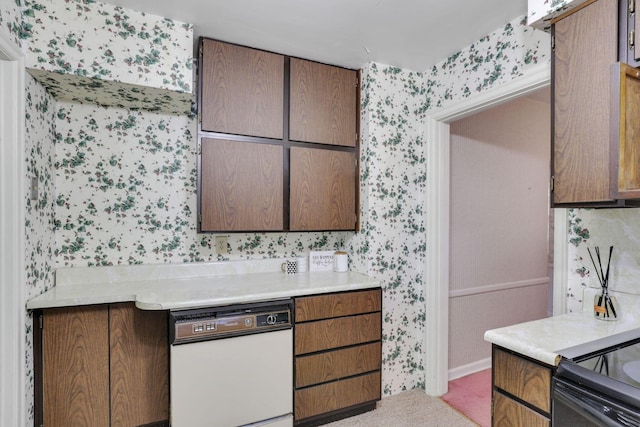 kitchen with wallpapered walls, light countertops, and light carpet