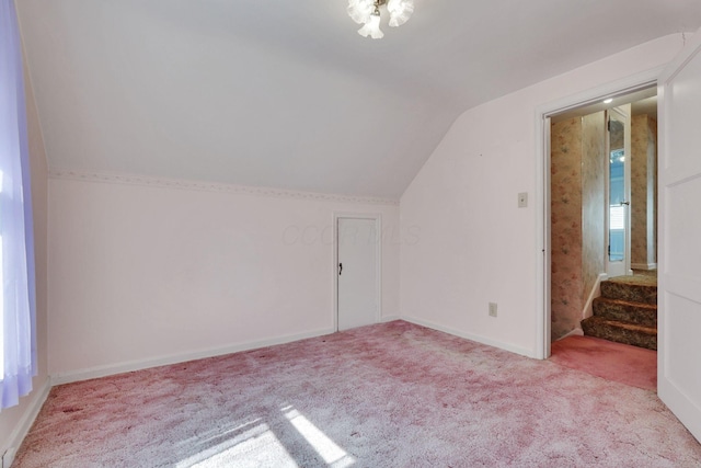 additional living space featuring carpet flooring, stairway, baseboards, and vaulted ceiling