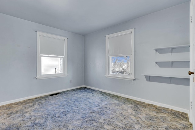 unfurnished room featuring visible vents, baseboards, and carpet