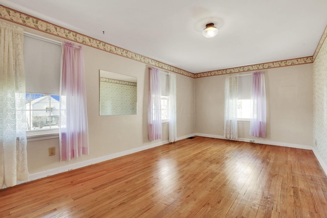 spare room with hardwood / wood-style floors and baseboards