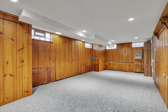 basement featuring wooden walls, recessed lighting, and carpet