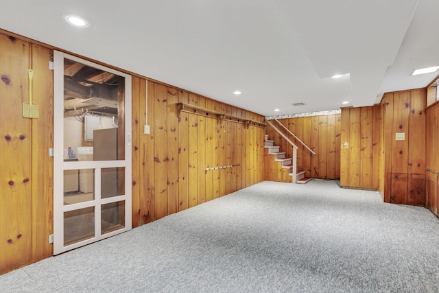 finished basement featuring stairs, carpet flooring, recessed lighting, and wood walls