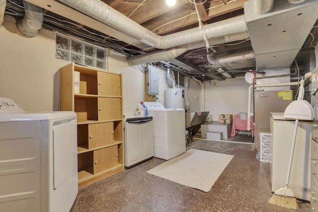 unfinished basement featuring washer and dryer, electric panel, and water heater