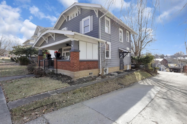 view of property exterior featuring covered porch and brick siding