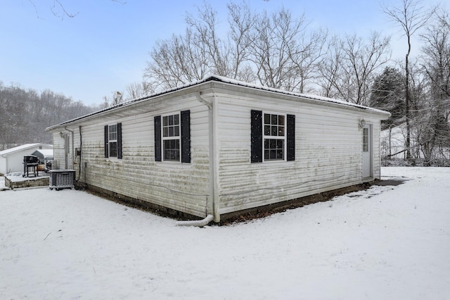 view of snow covered exterior featuring central AC unit