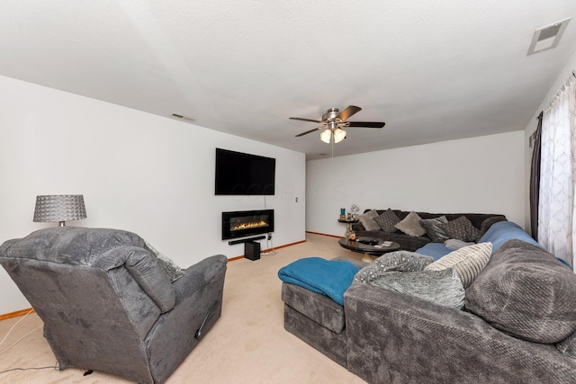 living room featuring ceiling fan, carpet floors, and a textured ceiling