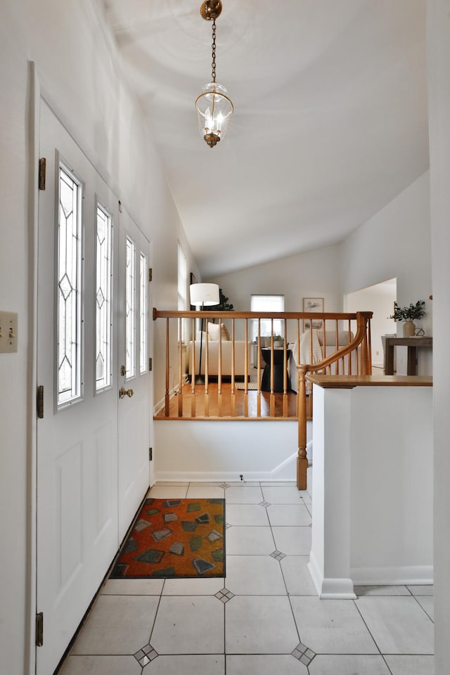 entryway with baseboards, lofted ceiling, stairway, tile patterned floors, and a chandelier