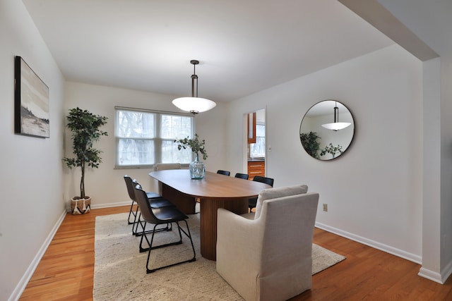 dining area featuring baseboards and light wood-style floors