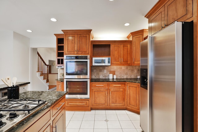 kitchen featuring appliances with stainless steel finishes, brown cabinets, backsplash, and open shelves