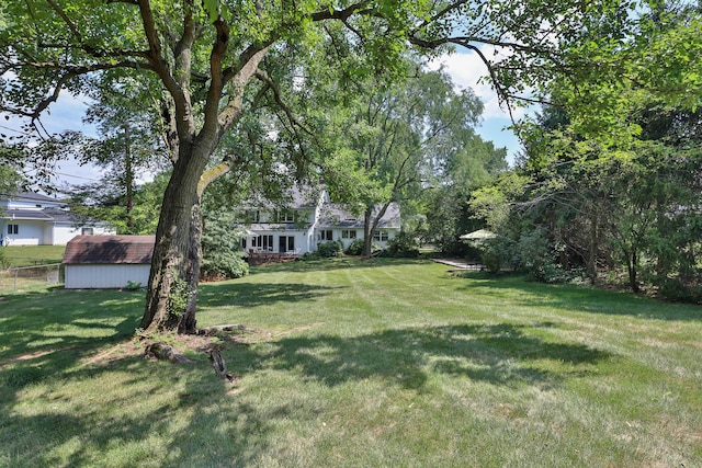 view of yard with fence and an outdoor structure