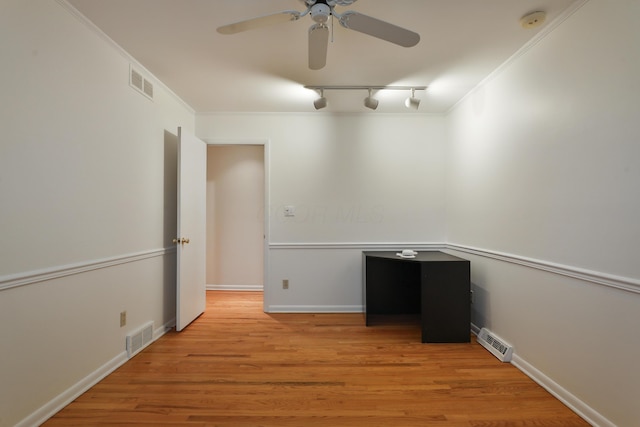 empty room featuring ornamental molding, light wood finished floors, and visible vents