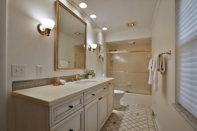 bathroom featuring toilet, ornamental molding, tile patterned flooring, combined bath / shower with glass door, and vanity