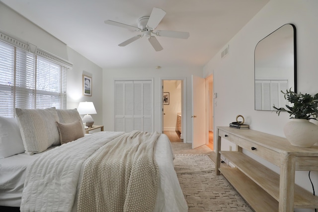 bedroom with ceiling fan, visible vents, and a closet