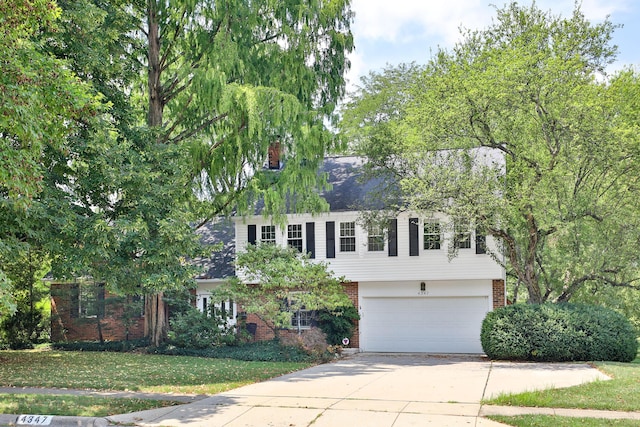 view of front of property with driveway, a garage, a front yard, and brick siding