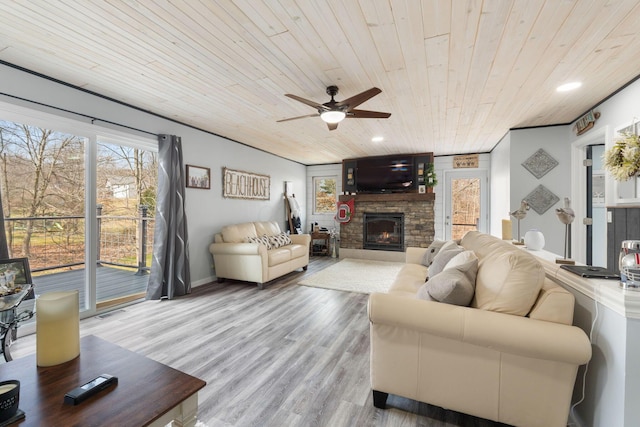 living room featuring wooden ceiling, ceiling fan, wood finished floors, a stone fireplace, and recessed lighting