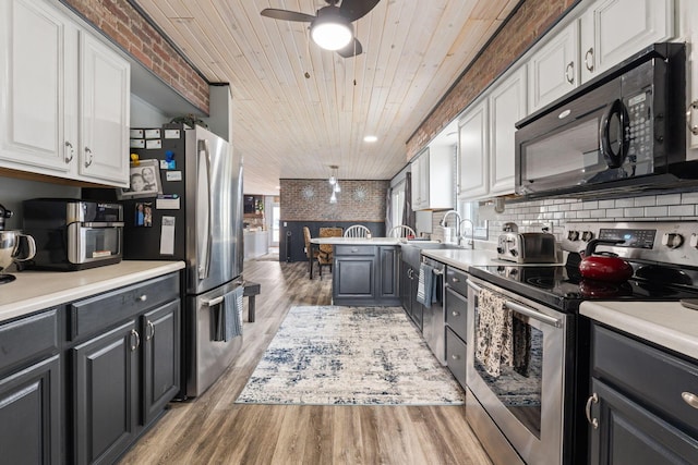 kitchen featuring wooden ceiling, stainless steel appliances, white cabinetry, a healthy amount of sunlight, and light wood finished floors