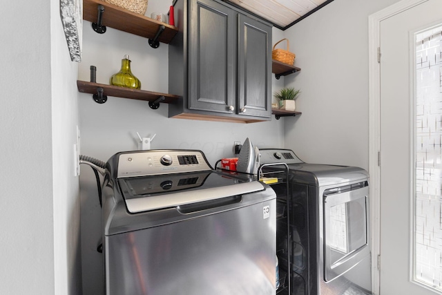 clothes washing area featuring cabinet space and washing machine and clothes dryer