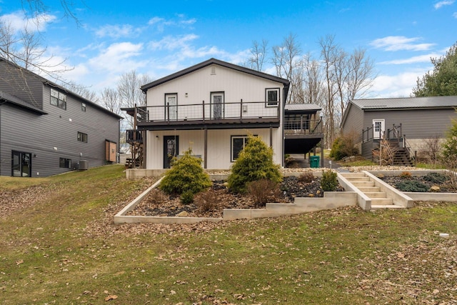 rear view of property with a yard, stairway, and a wooden deck