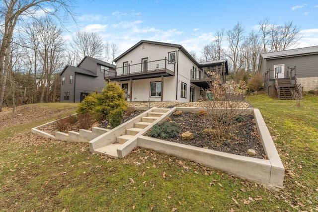 exterior space with stairs, a deck, and a front yard