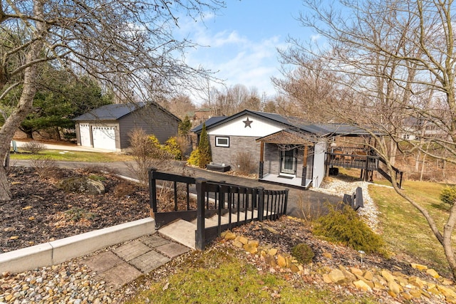 exterior space featuring a garage, an outbuilding, stone siding, and solar panels