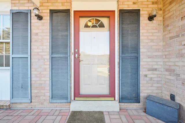 view of exterior entry featuring brick siding