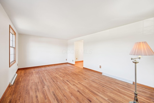 unfurnished room with baseboards, light wood-style floors, and baseboard heating