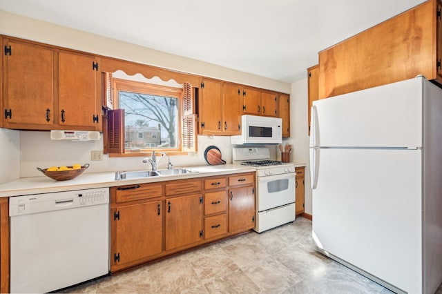 kitchen featuring brown cabinets, white appliances, light countertops, and a sink