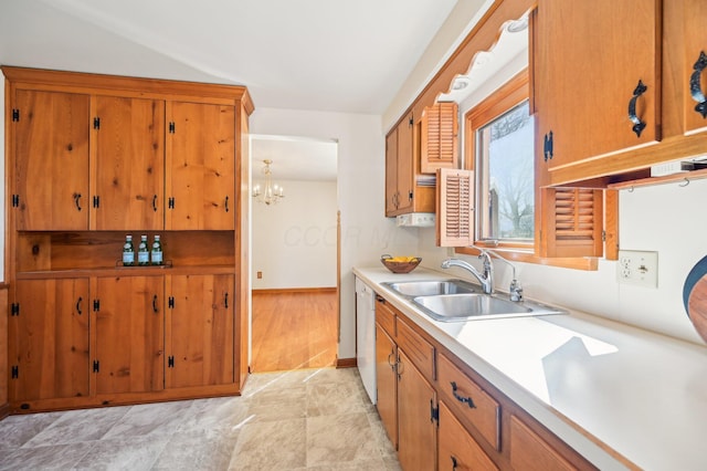 kitchen with baseboards, light countertops, white dishwasher, brown cabinetry, and a sink