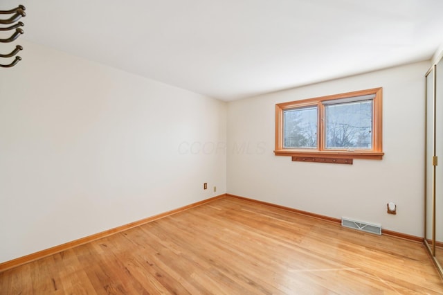 unfurnished room featuring visible vents, baseboards, and light wood-style flooring