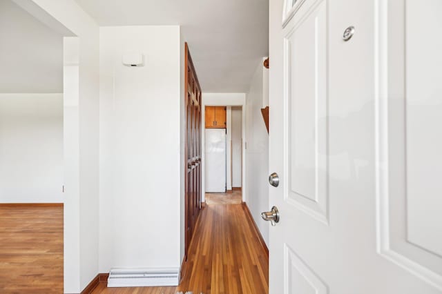 hallway with visible vents, baseboards, and wood finished floors