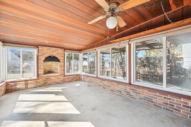 unfurnished sunroom with wooden ceiling and a ceiling fan