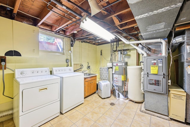 clothes washing area with water heater, a sink, and separate washer and dryer