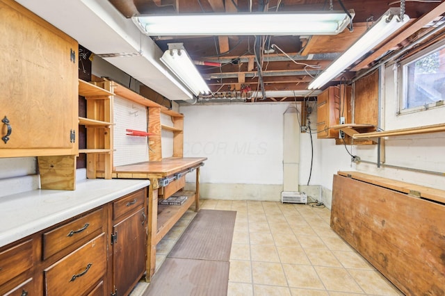 basement featuring a workshop area and light tile patterned flooring