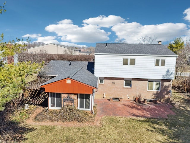 back of property featuring brick siding and a lawn