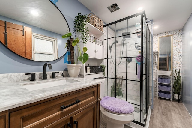 bathroom featuring vanity, toilet, an enclosed shower, and hardwood / wood-style floors