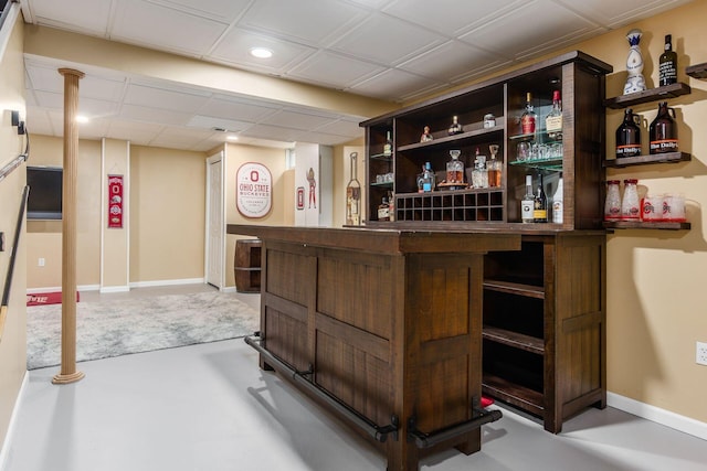 bar featuring a bar and baseboards