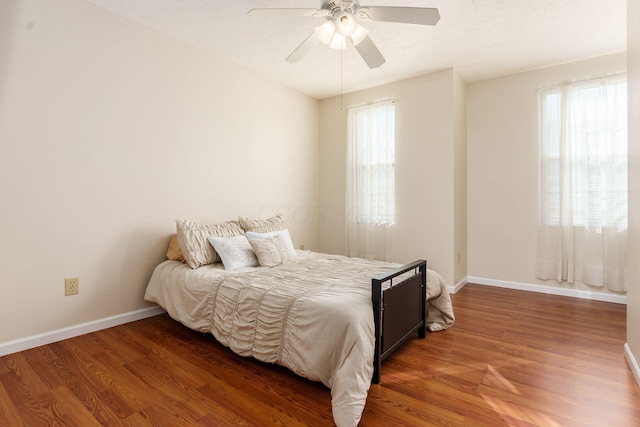 bedroom with wood finished floors, a ceiling fan, and baseboards