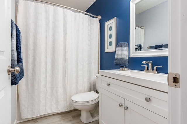 full bathroom with vanity, toilet, and wood finished floors