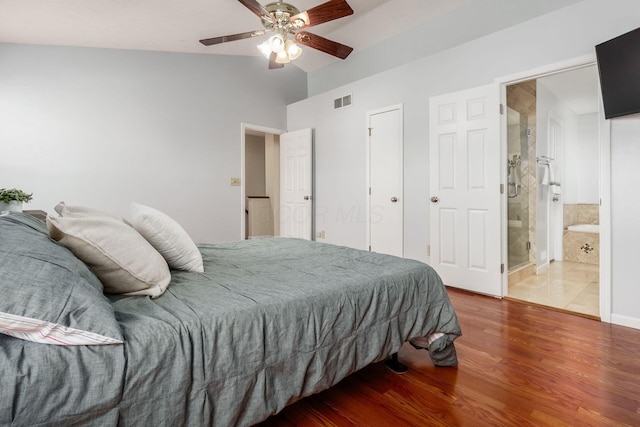 bedroom with visible vents, ceiling fan, wood finished floors, ensuite bathroom, and vaulted ceiling