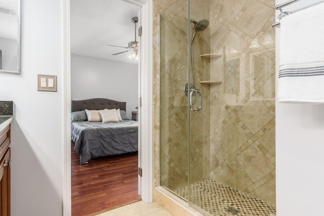 full bathroom with ensuite bathroom, vanity, a ceiling fan, a shower stall, and tile patterned floors