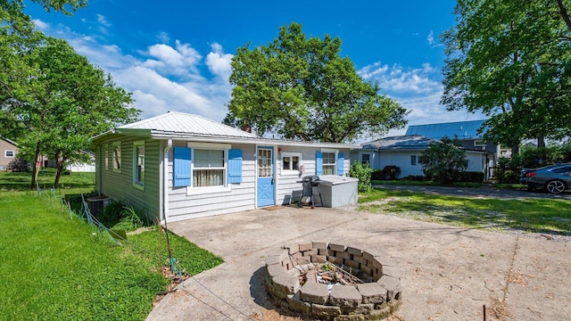109 Beacon Light Ln, Buckeye Lake, OH 43008 - view of front facade with a front lawn, a fire pit, metal roof, central AC, and driveway