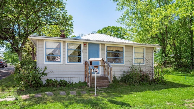 109 Beacon Light Ln, Buckeye Lake, OH 43008 - bungalow-style house with a chimney, a front yard, and metal roof