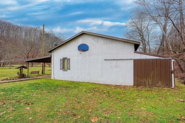 view of property exterior with a yard and an outbuilding