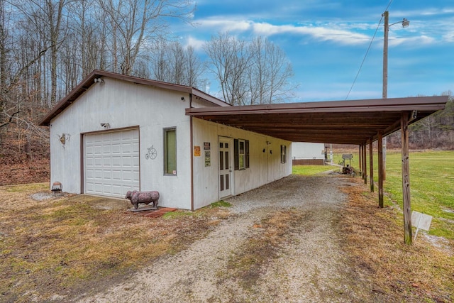 view of side of home with a garage, a yard, and a carport