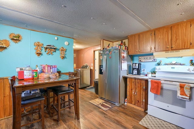 kitchen featuring washer and dryer, dark hardwood / wood-style floors, white electric stove, stainless steel fridge, and a textured ceiling