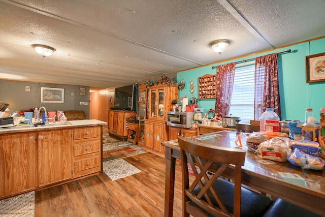 kitchen with sink, light hardwood / wood-style flooring, and a textured ceiling