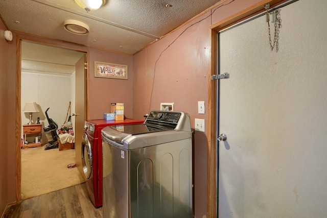 washroom featuring hardwood / wood-style floors, a textured ceiling, and independent washer and dryer