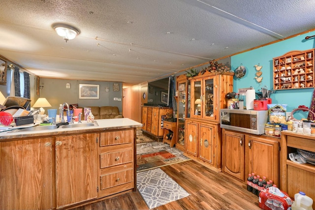 kitchen featuring sink, a textured ceiling, and light hardwood / wood-style flooring